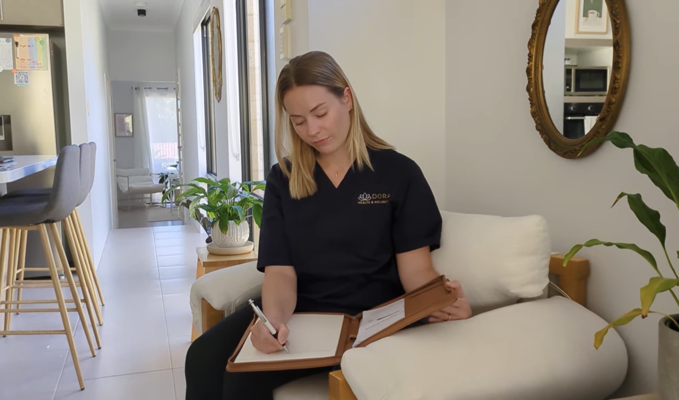 Georgina in Dora scrubs, writing up a care plan